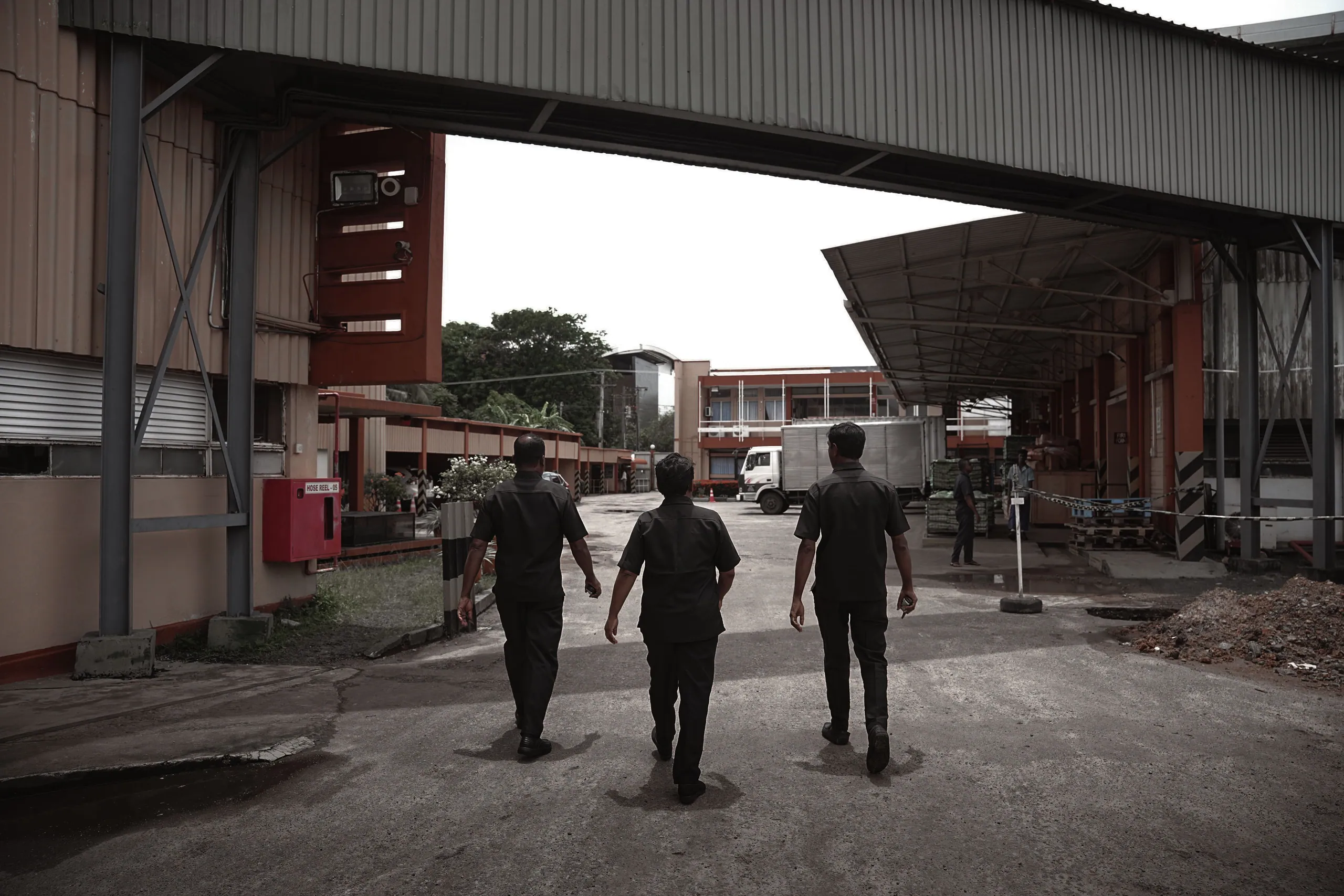 Three officers walking a client's factory yard together on deployment day